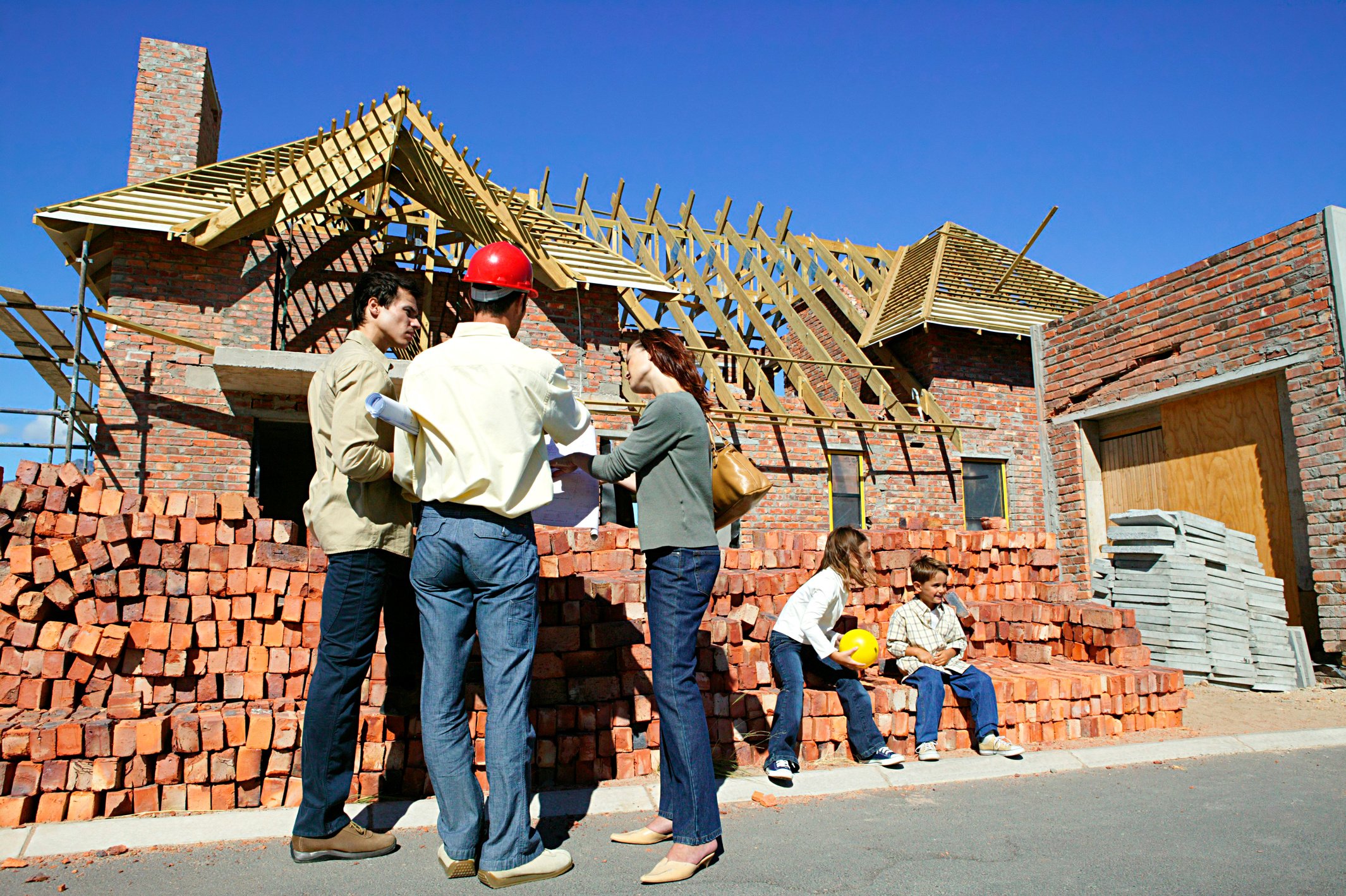 Contractor and client family at construction site